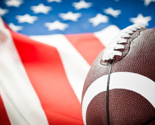 Image of a football with an American flag in the background