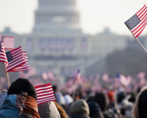 Image of people holding American flags outside of the U.S. capitol